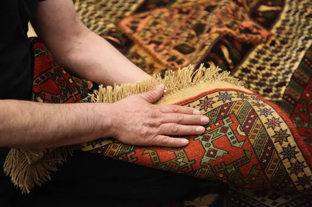 Teppich wird mit der Hand geprüft